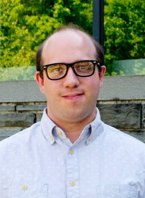 Man wearing collared shirt and black glasses